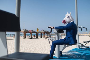 Şık takım elbise ve komik maskesi komik sporcu egzersizleri yapıyor