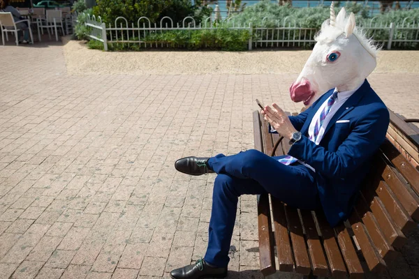 Giovane uomo divertente in abito elegante si siede sulla panchina sulla strada della città — Foto Stock