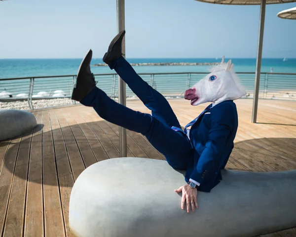 Young man in elegant suit falls down under umbrellas on the city waterfront — Stock Photo, Image