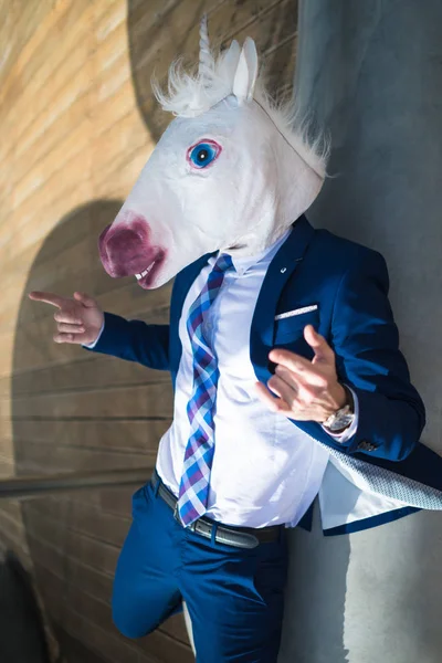 Ung framgångsrik manager i elegant kostym och rolig mask aktiva gestikulera — Stockfoto