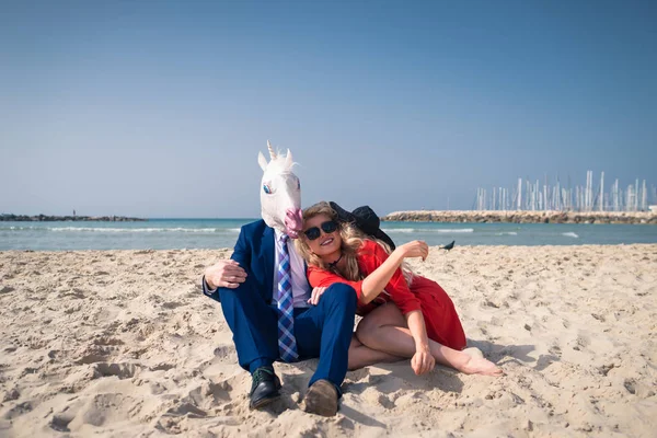 Смешной мужчина в элегантном костюме и маске с лошадиной головой с молодой женщиной — стоковое фото
