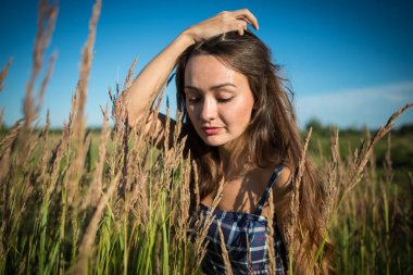 Çim sahada yaz günü içinde duran genç kadın