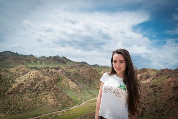 Mujer joven de pie en el fondo con vista a las montañas — Foto de Stock