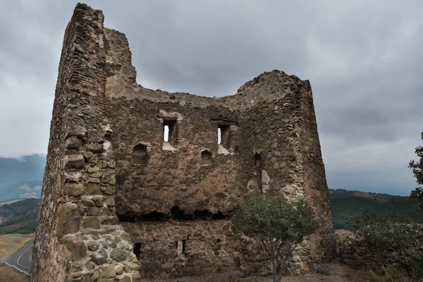 Antigua fortaleza en ruinas. Emoticono serio en la pared de piedra —  Fotos de Stock