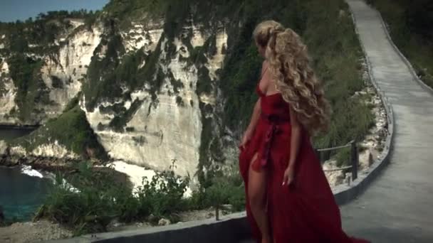 Mujer Joven Vestido Rojo Largo Elegante Caminando Por Carretera Acantilado — Vídeo de stock