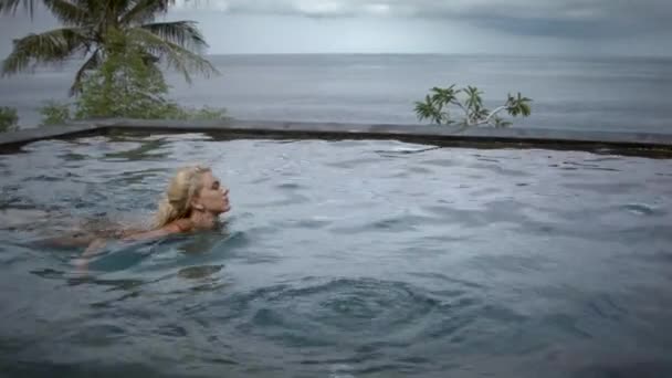 Jeune Femme Sérieuse Aux Cheveux Blonds Nageant Dans Piscine Infinie — Video