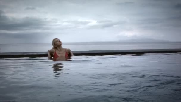 Jovem Séria Com Cabelo Loiro Maiô Vermelho Relaxando Piscina Infinita — Vídeo de Stock