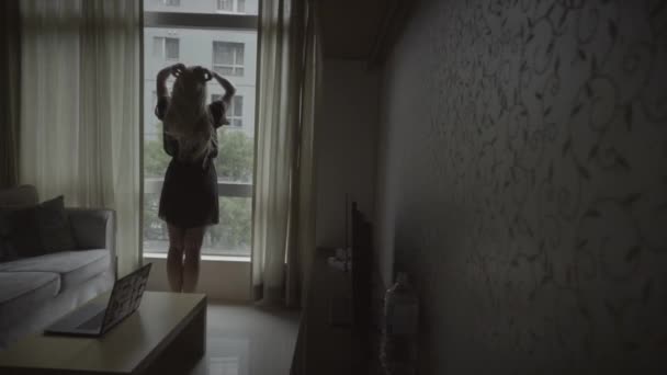 근처에 머리의 잠옷을 여자가 아파트에서 일어나고 뒷모습 — 비디오