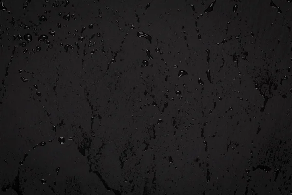 Капли воды на темной каменной поверхности — стоковое фото
