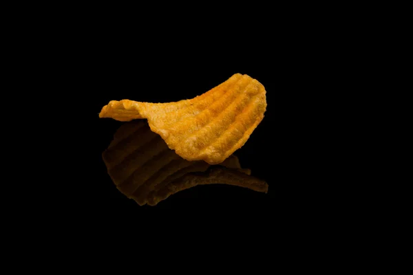 Potatis chip på svart yta — Stockfoto