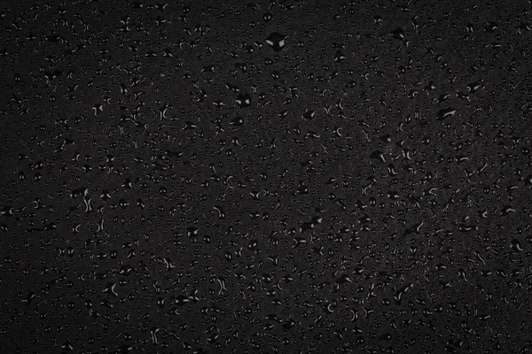 Капли воды на темном камне — стоковое фото