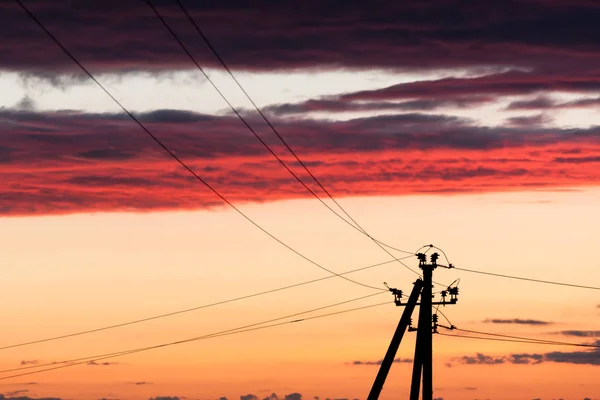 Línea eléctrica contra el cielo colorido al atardecer — Foto de Stock