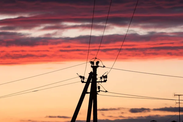 Línea eléctrica contra el cielo colorido al atardecer — Foto de Stock