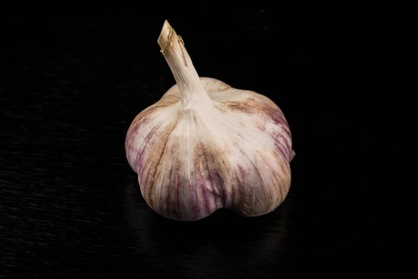 Knoblauchknolle auf dunklem Hintergrund — Stockfoto