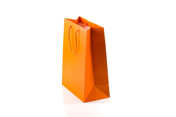 Bolsa de papel naranja aislada en ángulo diagonal blanco —  Fotos de Stock