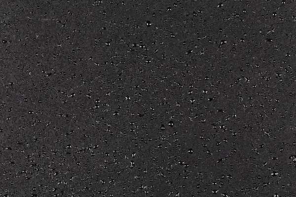 Wassertropfen auf dunklen Stein — Stockfoto