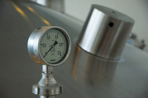 Pressure gauge, close-up. Pressure gauge showing zero bar, attached to beer fermentation tank. Interiors of an industrial beer brewery. Pressure meter - manometer barometer. Pressure differential gauge.