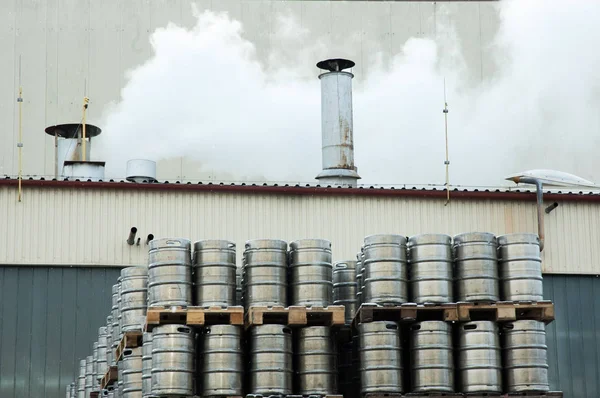 酿酒厂的外部。 工作流，烟道冒出来的烟 大量的钢桶. 免版税图库图片