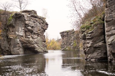 Nehir, kanyon kayalıklarının arasından esiyor. Güzel sonbahar manzarası. Nehir ve kayalar. Sonbahar ağaçları. 