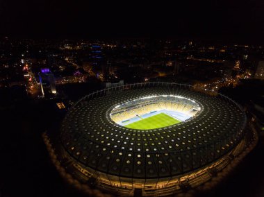 İnsansız Olimpiyat Stadyumu. Şehrin yukarıdan panoramik manzarası ve ışıkları var. Gece vakti. Maçtan önce stadyum.