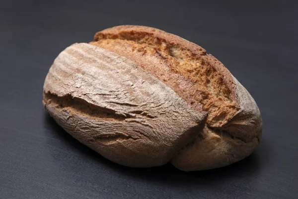 Appetizing freshly baked bread on a black background. Isolated loaf of bread — Stock Photo, Image