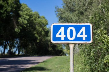 Yol işareti 404. Üzerinde 404 yazan gerçek bir yol tabelası. Üzerinde beyaz sayılar olan dikdörtgen mavisi bir işaret..