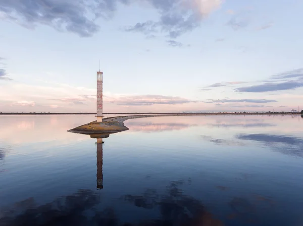 Lighthouse at sunset. An incredible landscape. Calm water surface and beautiful sky. Beauty of nature. — ストック写真
