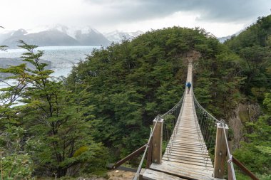 Hiker on Long Suspension Bridge