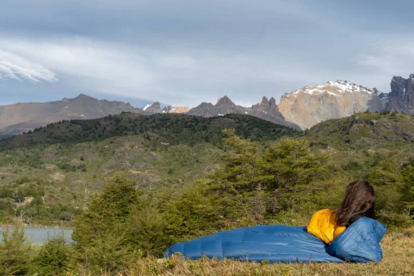 Girl in sleeping bag in mountains near lake — Stock Photo, Image