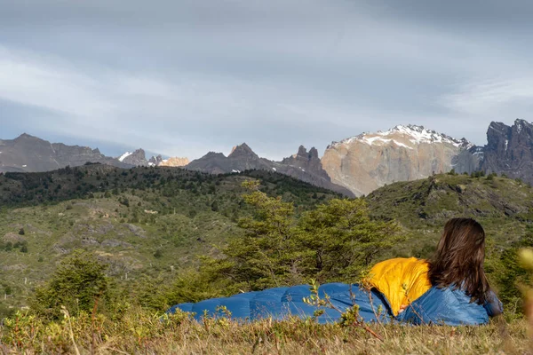 Girl in sleeping bag in mountains near lake — Stock Photo, Image