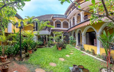 Ağaçlar ve ahşap banklarla çevrili Avlu