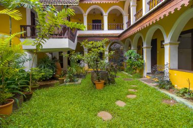 Ağaçlar ve ahşap banklarla çevrili Avlu