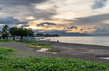 Kuzey Bali 'de gün batımında sahilde tekneler