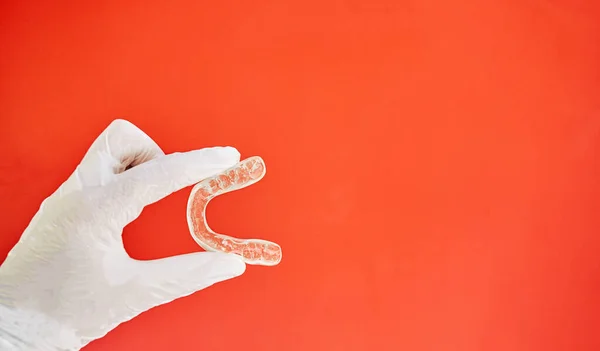 Onzichtbare Armbanden Een Rode Achtergrond Een Hand Gehouden Door Een — Stockfoto