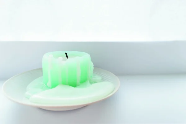 Masanın üzerinde açık renkli bir mum var.