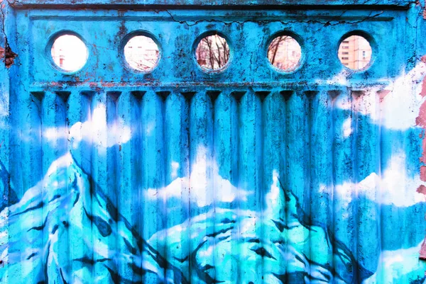 Eski unutulmuş bir çitin üzerine grafiti, karlı tepeli dağlar tasvir edilir.