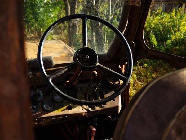 Controls the old tractor. Steering wheel and levers at the rusty tractor