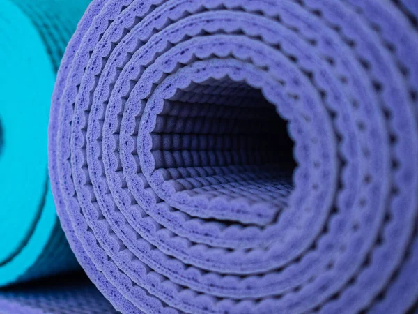 Mats for yoga, fitness or Pilates. Blue and purple mats for sports activities