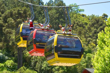 Calena, Rio Grande do Sul - 20 / 11 / 2019: Güney Brezilya 'daki Caracol Park' ta insanları taşırken üç renkli gondol (teleferik)