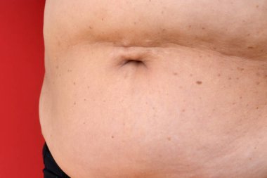 Kadın göbeği. Aşırı kilo sorunları. Sağlıklı yaşam tarzı konsepti. Obezitenin arkaplanı