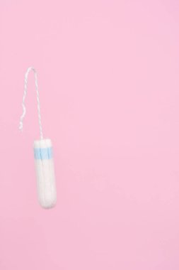 Pembe arka planda tıbbi kadın flyeng tamponu. Kadınlar için hijyenik beyaz tampon. Pamuklu çubuk. Regl, korunma aracı. Pembe arkaplanda tamponlar.