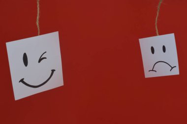 Beyaz bir çarşafın üzerinde boyalı bir gülümseme. Pozitif düşünce konsepti. Bazı kötü hisleri saklamak sadece gülümsemeye devam etmek