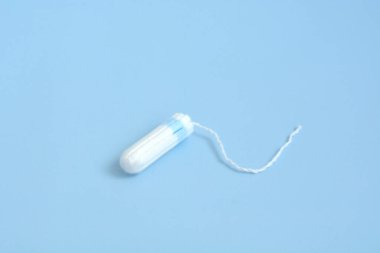 Pembe arka planda tıbbi kadın flyeng tamponu. Kadınlar için hijyenik beyaz tampon. Pamuklu çubuk. Regl, korunma aracı.