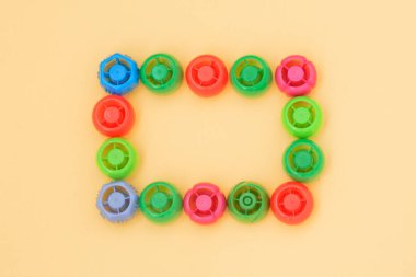 Plastik mantar çerçevesi. Bebek mamasından gelen çok renkli plastik mantar, sıfır yaşam tarzı atık, geri dönüşüm çöpü, çevre bilinci