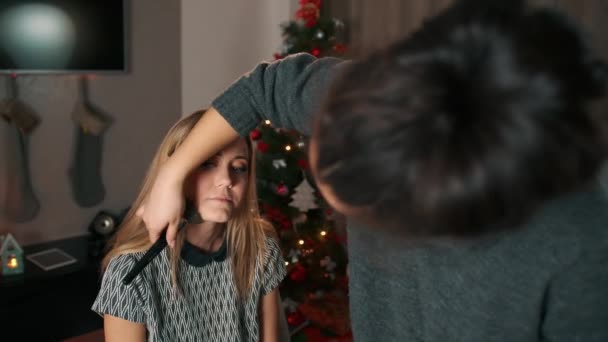 Professionele Aziatische make-up kunstenaar maakt een make-up. Breng poeder aan op het gezicht van het model met een grote kwast. In het interieur ingericht voor de viering van Kerstmis. — Stockvideo