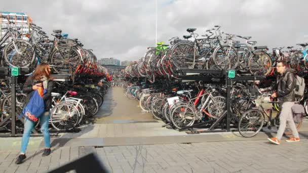 Amszterdam, Hollandia - 2019. október: A helyiek kerékpárral közlekednek egy nagy kétemeletes kerékpárparkolóban. Környezetvédelmi koncepció. — Stock videók