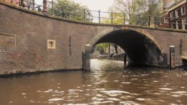 Amsterdam, Hollanda - Eylül 2019: Romantik gün batımı köprünün kemerinde parlıyor.