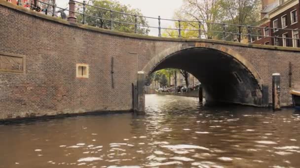 Amszterdam, Hollandia - 2019. szeptember: romantikus naplemente ragyog a híd ívén keresztül. — Stock videók