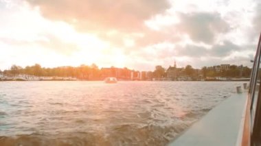 Amsterdam, Hollanda - Eylül 2019: Amstel Nehri ve Ij Gölü üzerinde gün batımı. Turist yolcu teknesinden görüntü.