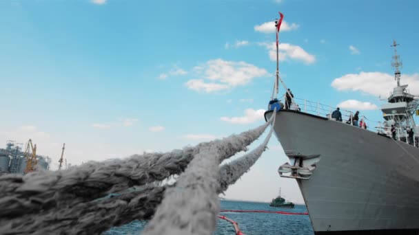 A kanadai zászlóval ellátott Nato hadihajó a kikötőben horgonyoz. Azonosítatlan emberek fedélzetén. A hajót horgonyzó kötelek közelsége. A háború befejezésének koncepciója — Stock videók